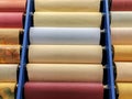 Colored wallpaper rolls on store shelves. Paper material for repair