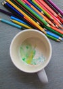 Colored watercolor pencils in a mug. Colorful water drops. Creation Royalty Free Stock Photo