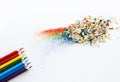 Colored watercolor pencils of rainbow colors and shavings from them after sharpening on a white background. Royalty Free Stock Photo