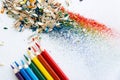 Colored watercolor pencils of rainbow colors and shavings from them after sharpening on a white background. Royalty Free Stock Photo