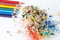 Colored watercolor pencils of rainbow colors and shavings from them after sharpening on a white background Royalty Free Stock Photo