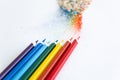 Colored watercolor pencils of rainbow colors and shavings from them after sharpening on a white background Royalty Free Stock Photo