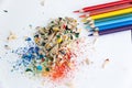 Colored watercolor pencils of rainbow colors and shavings from them after sharpening on a white background Royalty Free Stock Photo