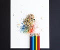 Colored watercolor pencils of rainbow colors and shavings from them after sharpening on a white background Royalty Free Stock Photo