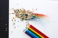 Colored watercolor pencils of rainbow colors and shavings from them after sharpening on a white background Royalty Free Stock Photo