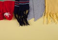 Colored winter warm scarfs on an isolated yellow background