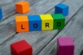 Colored wooden cubes with letters. the word lord is displayed, abstract illustration