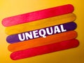 Colored wooden stick with the word UNEQUAL Royalty Free Stock Photo