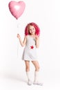 Colores hairs. Portrait of funny fashion hipster girl with pink ballon in the shape of heart Royalty Free Stock Photo