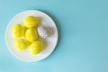 Colorfool bright easter eggs in white plate a row yellow isolated on yellow background Royalty Free Stock Photo