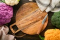 Colorfu cauliflower. Cutting wooden board and various sort of cauliflower on old wooden background. Abstract food background. Pur