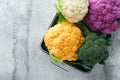 Colorfu cauliflower. Various sort of cauliflower on gray concrete background. Purple, yellow, white and green color cabbages. Broc Royalty Free Stock Photo