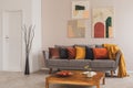 Colorful abstract painting above grey couch with pillows in scandinavian design interior Royalty Free Stock Photo