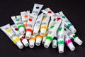 Colorful acrylic paints in tubes on dark Royalty Free Stock Photo