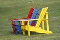 Colorful Adirondack chairs on green grass