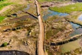 A colorful aerial view of a road embankment for trucks in an overgrown sand pit