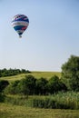 Colorful air balloon flies over the city suburbs.