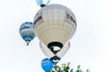 Colorful air balloons with different logos flying over the cloudy sky during the European festival