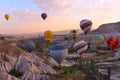 Colorful air balloons fly up into the sky at sunrise among a beautiful rocky landscape. C Royalty Free Stock Photo