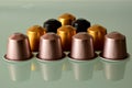 Colorful aluminum coffee capsules on gray glass with reflection