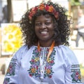 Colorful american woman dressed in Ukrainian clothes embroidery on a street in the city center Lviv, Ukraine