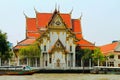 Colorful ancient old buddhist temple in Bangkok city cwith orange tiled roof on the river. Thailand