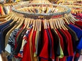 Colorful apparel hanging on wooden hangers on a round iron rail