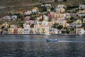Colorful architecture on the sea coast of Symi island, Greece. A small blue fishing boat on water.