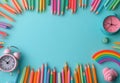 Colorful arrangement of pencils and clock on a turquoise background for creative projects Royalty Free Stock Photo