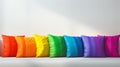 A colorful array of cushions arranged in rainbow sequence on a light background