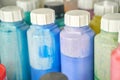 Colorful array of paint bottles in various shades of blue, green, and purple