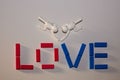 Colorful array of plastic blocks arranged to spell out the word 'love' with two toy figures