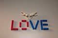 Colorful array of plastic blocks arranged to spell out the word 'love' with two toy figures