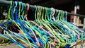 A Colorful Array of Plastic Clothes Hangers Hanging Outdoors on a Metal Rail in Sunlight Royalty Free Stock Photo