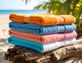 A colorful array of vibrant beach towels neatly folded on a stack of driftwood, ready for sunbathing Royalty Free Stock Photo