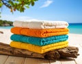 A colorful array of vibrant beach towels neatly folded on a stack of driftwood, ready for sunbathing Royalty Free Stock Photo