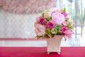 Colorful artificial flowers made from cloth in a rectangular ceramic vase