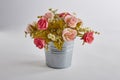 Colorful artificial rose flowers in pot on white background