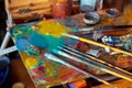 Colorful artist's palette with pastel and oil brushes in art studio Royalty Free Stock Photo