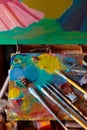 Colorful artist's palette with pastel and oil brushes in art studio Royalty Free Stock Photo