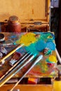 Colorful artist's palette with pastel and oil brushes in art studio Royalty Free Stock Photo
