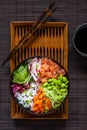 Colorful Asian trendy food, sushi poke bowl with rice, cucumber, salmon, carrot, edamame beans and soy sauce. Top view, close up Royalty Free Stock Photo