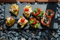 Colorful Assorted Canap s On Slate Bed Outdoors With Fresh Tomatoes, Cheese, and Herbs Royalty Free Stock Photo