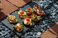 Colorful Assorted Canap s On Slate Bed Outdoors With Fresh Tomatoes, Cheese, and Herbs Royalty Free Stock Photo