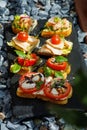 Colorful Assorted Canap s On Slate Bed Outdoors With Fresh Tomatoes, Cheese, and Herbs Royalty Free Stock Photo