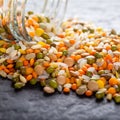 Colorful assorted lentils and whole grains seeds poured from a glass jar on the table