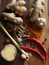 A colorful assortment of Asian spices showcases fresh ginger, garlic, vibrant chili peppers, star anise, and aromatic