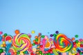 Colorful candies, top view bottom border on a blue background