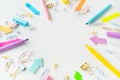 Colorful assortment of office supplies including pens, markers, paper clips and paper clips scattered on a white Royalty Free Stock Photo