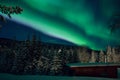 Colorful aurora borealis over mountain, forest and garage Royalty Free Stock Photo